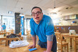 © Trevor Adeline/Caia Image - Portrait confident young man with Down Syndrome working in cafe