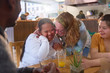 © Trevor Adeline/Caia Image - Happy mentor and young women with Down Syndrome laughing in cafe