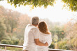 © Justin Pumfrey/Caia Image - Affectionate couple hugging looking at autumn trees on patio