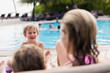 © Paul Bradbury/Caia Image - Mother and sons relaxing at poolside