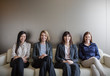 © Martin Barraud/Caia Image - Portrait smiling businesswomen sitting in a row on sofa