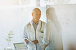 © Tom Merton/Caia Image - Smiling male doctor showing digital tablet to female patient in doctor‚Äôs office