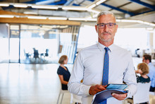 Portrait Confident Businessman With Digital Tablet In Office