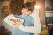 © Justin Pumfrey/Caia Image - Enthusiastic young woman hugging boyfriend holding birthday gift