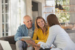 © Tom Merton/Caia Image - Financial advisor with digital tablet meeting with couple in living room