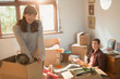 © Justin Pumfrey/Caia Image - Portrait smiling young couple unpacking moving boxes in apartment
