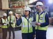 © Ryan Lees/Caia Image - Workers with clipboard talking in distribution warehouse