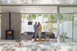 © Tom Merton/Caia Image - Couple using laptop in modern living room open to patio