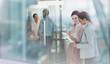 © Tom Merton/Caia Image - Businesswomen talking, reviewing paperwork in office
