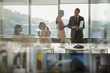© Tom Merton/Caia Image - Business people talking, using laptop in conference room meeting