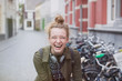 © Sam Edwards/Caia Image - Portrait enthusiastic, laughing young woman with headphones on city street
