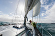 © Martin Barraud/Caia Image - Woman at bow of sailboat on sunny ocean, Vava'u, Tonga, Pacific Ocean