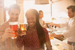 © Tom Merton/Caia Image - Portrait smiling couple toasting beer glasses at bar