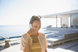 © Tom Merton/Caia Image - Smiling woman talking on smart phone on sunny modern, luxury home showcase exterior patio