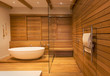 © Tom Merton/Caia Image - Soaking tub and shower surrounded by wood walls in modern, luxury home showcase interior bathroom