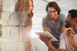 © Tom Merton/Caia Image - Smiling creative business people planning, using digital tablet in meeting