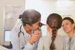 © Tom Merton/Caia Image - Female pediatrician using otoscope, checking ear of girl patient in examination room
