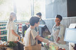 © Tom Merton/Caia Image - Smiling female cashier helping customer at grocery store checkout