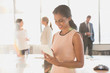 © Tom Merton/Caia Image - Businesswoman using digital tablet in sunny conference room