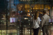 © Tom Merton/Caia Image - Businessman and businesswoman looking out urban office window at night