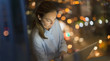 © Tom Merton/Caia Image - Serious, focused businesswoman working late at laptop in office window at night