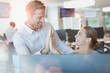 © Tom Merton/Caia Image - Businessman and businesswoman high-fiving at computer in office