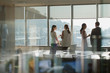 © Tom Merton/Caia Image - Business people talking at sunny window in conference room meeting