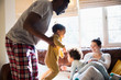 © Sam Edwards/Caia Image - Playful multi-ethnic family in pajamas in living room