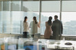 © Tom Merton/Caia Image - Business people looking out sunny window in urban conference room