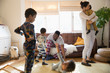 © Sam Edwards/Caia Image - Multi-ethnic young family in pajamas playing and relaxing in living room