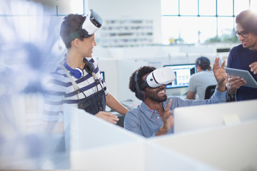 Computer programmers testing virtual reality simulators in office