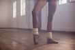 © Sam Edwards/Caia Image - Young female ballet dancer stretching foot in dance studio