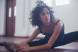 © Sam Edwards/Caia Image - Focused young female dancer stretching leg in dance studio