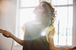 © Sam Edwards/Caia Image - Carefree young female dancer listening to music with headphones and mp3 player in sunny studio