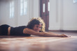 © Sam Edwards/Caia Image - Smiling, carefree young female dancer stretching on dance studio floor