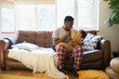 © Sam Edwards/Caia Image - Affectionate father in pajamas cuddling with baby son on living room sofa