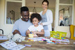 © Sam Edwards/Caia Image - Parents and daughter coloring at table