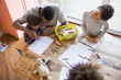 © Sam Edwards/Caia Image - Father and children coloring at table