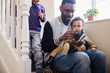 © Sam Edwards/Caia Image - Father putting shoes on baby son