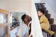 © Sam Edwards/Caia Image - Playful father and toddler son crawling up stairs