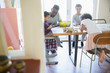 © Sam Edwards/Caia Image - Father and children coloring at dining table