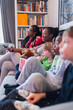 © Paul Bradbury/Caia Image - Family watching movie and eating popcorn on living room sofa
