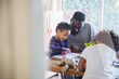 © Sam Edwards/Caia Image - Father and toddler son coloring at table