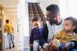 © Sam Edwards/Caia Image - Father putting shoes on baby son on stairs