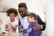 © Sam Edwards/Caia Image - Father and toddler children baking in kitchen