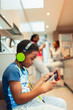 © Paul Bradbury/Caia Image - Boy with headphones and digital tablet playing video game