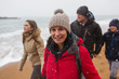 © Sam Edwards/Caia Image - Portrait smiling woman in warm clothing with family on snowy winter ocean beach