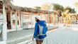 © Paul Bradbury/Caia Image - Young female backpacker arriving at beach hut