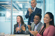 © Robert Daly/Caia Image - Business people smiling and clapping in conference room meeting