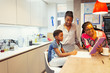 © Paul Bradbury/Caia Image - Family with digital tablet in kitchen